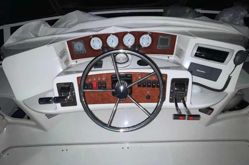 Slide: The Image of Control panel of a 2005 Silverton 35 Motor Yacht with steering wheel and gauges. - 13