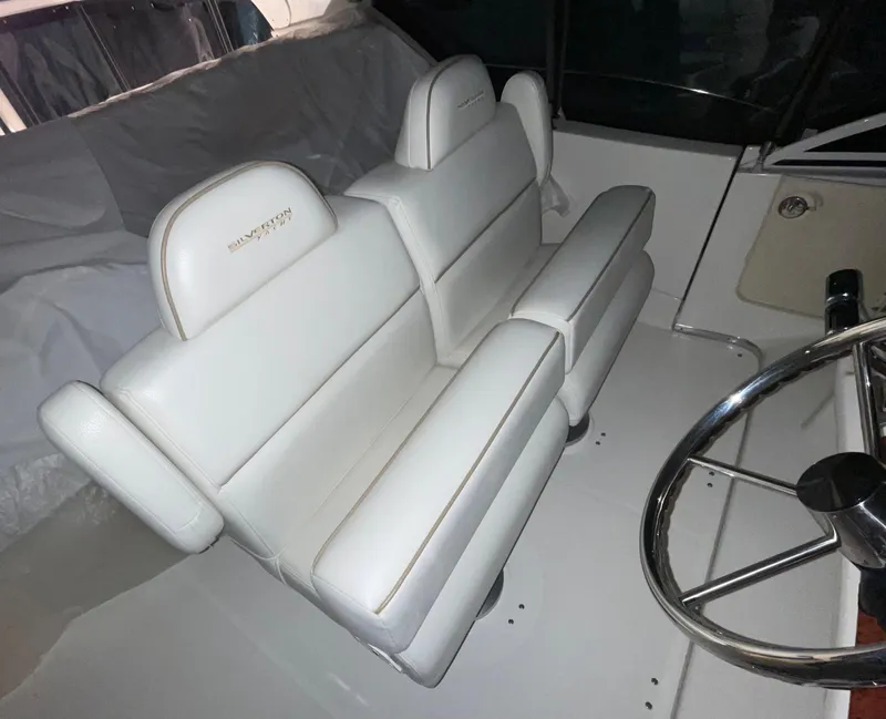 Slide: The Image of 2005 Silverton 35 Motor Yacht helm with white leather seating and steering wheel. - 14