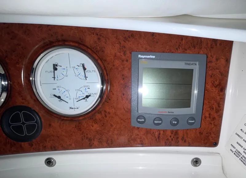 Slide: The Image of Control panel of a 2005 Silverton 35 Motor Yacht with gauges and Raymarine display. - 15