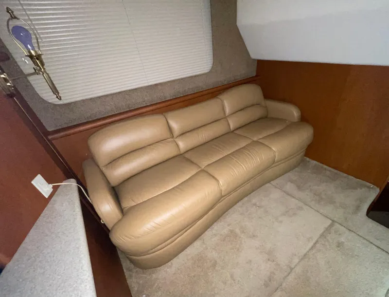 Slide: The Image of 2005 Silverton 35 Motor Yacht interior with beige leather sofa and carpeted floor. - 28