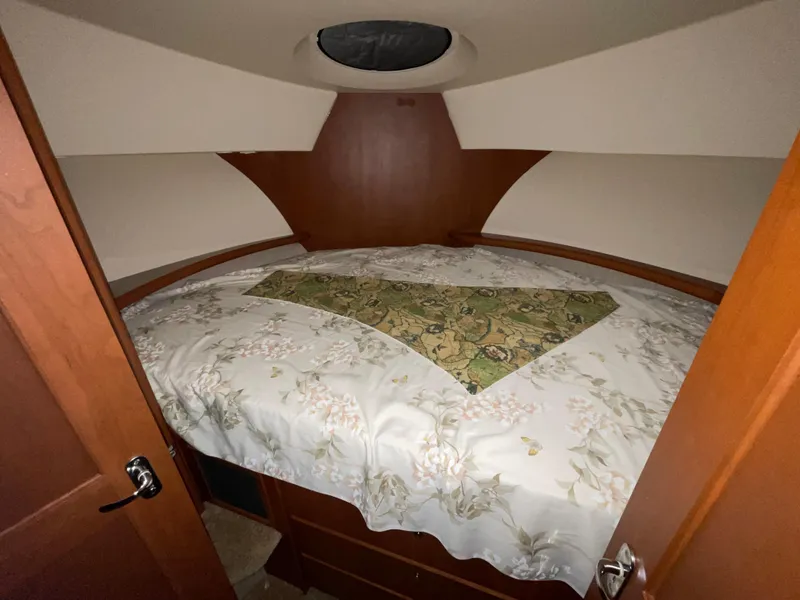 Slide: The Image of 2005 Silverton 35 Motor Yacht bedroom with floral bedding and wood paneling. - 31