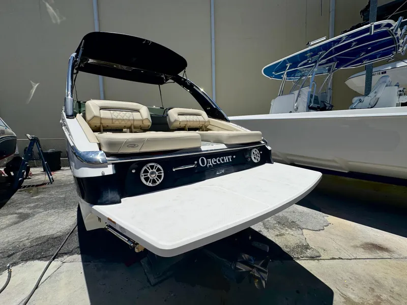 Slide: The Image of 2020 Regal LS4 boat with beige seating, docked in a marina, showcasing sleek design. - 19