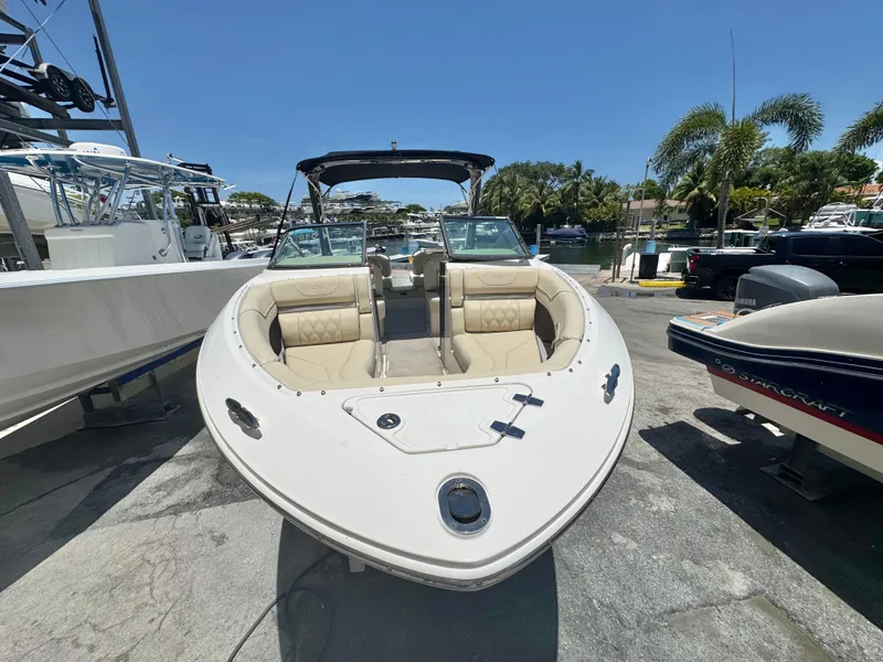 Slide: The Image of 2020 Regal LS4 boat with beige seating, docked near palm trees and other boats. - 4