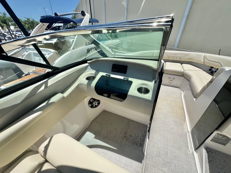 Slide: The Image of 2020 Regal LS4 boat interior with beige seating, glass windshield, and cup holders. - 9