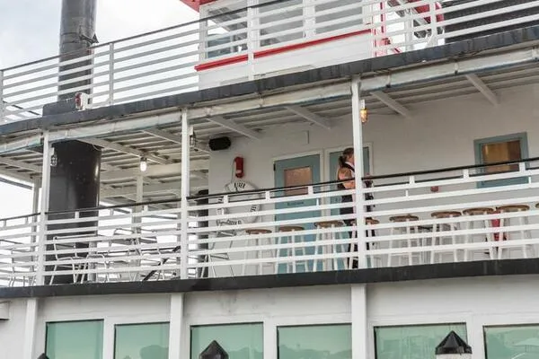 Slide: The Image of A 1984 custom paddle wheel boat with white railings and outdoor seating. - 11