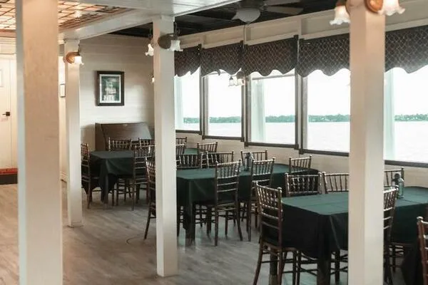 Slide: The Image of Interior of a 1984 custom paddle wheel boat with dining tables and river view. - 17