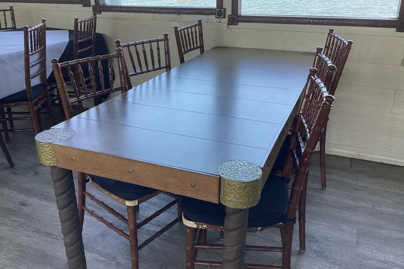 Slide: The Image of Elegant dining setup with wooden chairs and a custom paddle wheel table, 1984 design. - 27