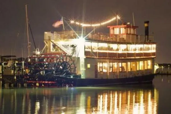 Slide: The Image of Vintage 1984 custom paddle wheel boat illuminated at night, reflecting on calm water. - 3