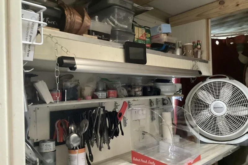 Slide: The Image of Kitchen storage with utensils, fan, and shelves in a compact space, Custom Paddle Wheel, 1984. - 33
