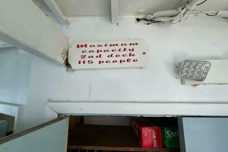Slide: The Image of Sign indicating maximum capacity of 115 people on the second deck of a 1984 custom paddle wheel. - 36