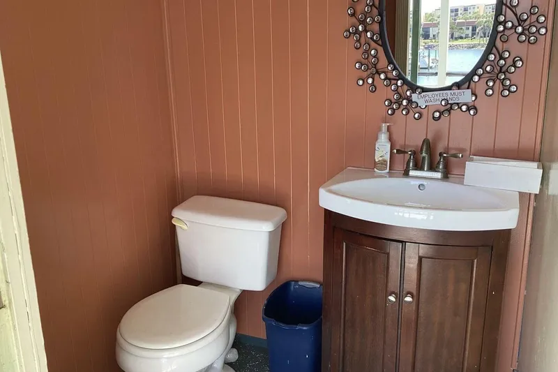 Slide: The Image of Small bathroom with toilet, sink, decorative mirror, and "Employees Must Wash Hands" sign. - 37