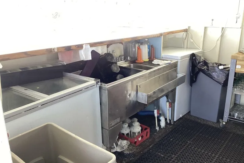 Slide: The Image of Commercial kitchen sink area with storage, cleaning supplies, and equipment. Custom Paddle Wheel, 1984. - 39