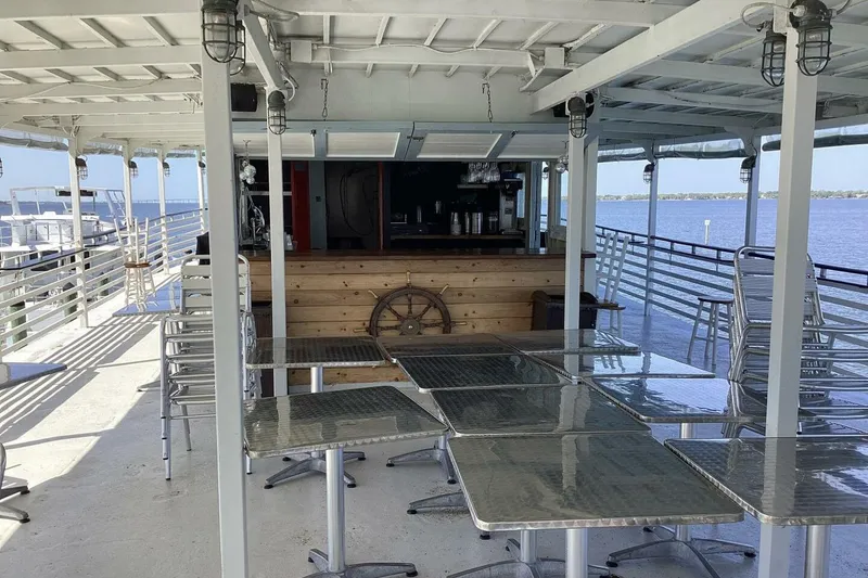 Slide: The Image of Open deck of a 1984 custom paddle wheel boat with tables and a bar. - 48