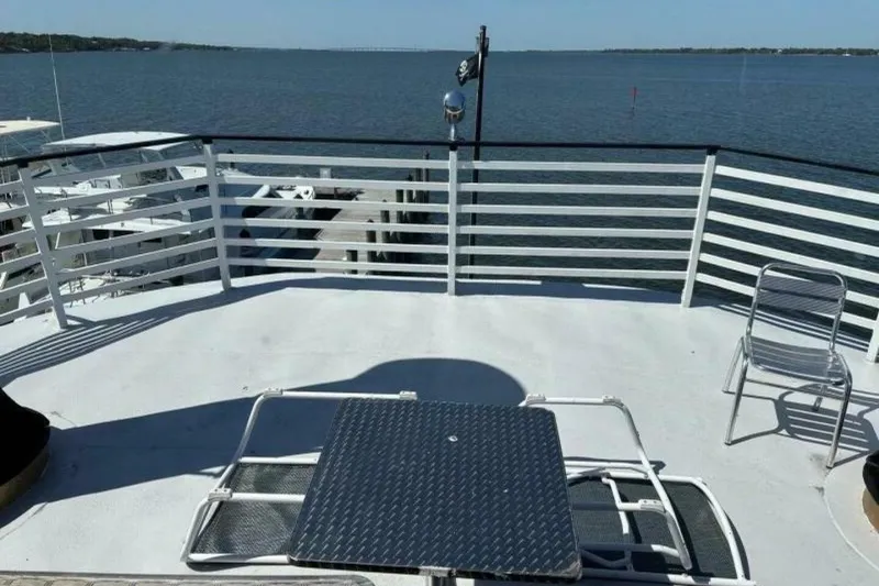 Slide: The Image of Rooftop deck of a 1984 Custom Paddle Wheel boat overlooking a serene waterfront. - 49
