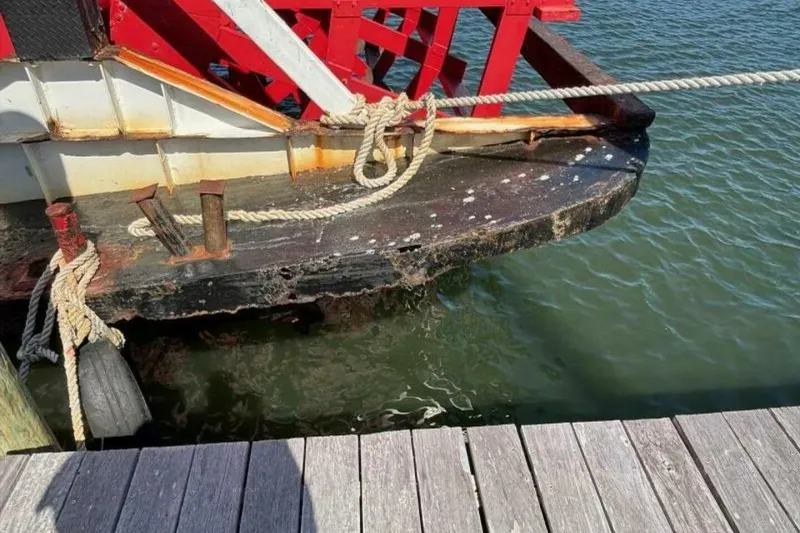 Slide: The Image of Close-up of a 1984 custom paddle wheel boat docked, showing ropes and weathered wood. - 65