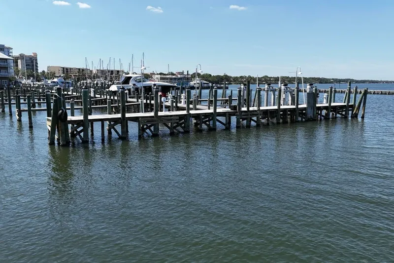 Slide: The Image of Marina with wooden docks and boats under a clear blue sky. - 77