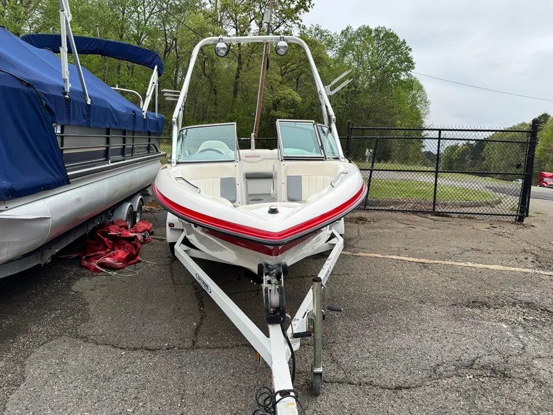 Slide: The Image of 2001 MasterCraft X-Star boat on trailer, parked outdoors near other boats. - 2