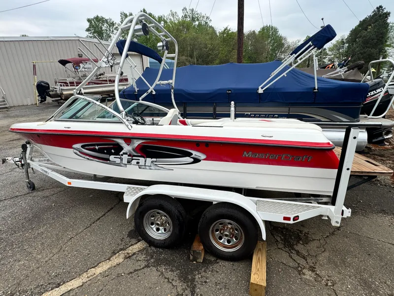 Slide: The Image of 2001 MasterCraft X-Star boat on trailer, red and white design, parked outdoors. - 5