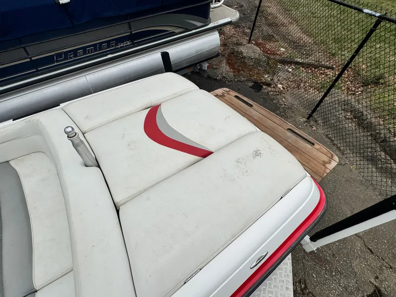 Slide: The Image of 2001 MasterCraft X-Star boat with white and red seating, docked near a fence. - 7