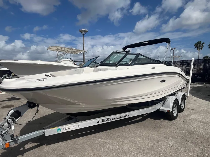 Slide: The Image of 2020 Sea Ray SPX 210 OB boat on trailer, parked outdoors under cloudy sky. - 2