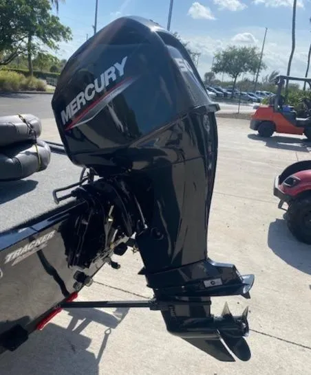 Slide: The Image of 2024 Tracker Bass Tracker Classic XL with Mercury outboard motor in a sunny outdoor setting. - 11