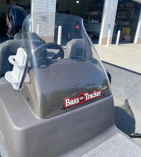 Slide: The Image of 2024 Tracker Bass Tracker Classic XL boat console with windshield in a garage setting. - 16