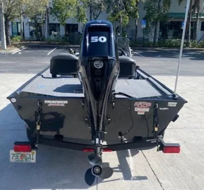 Slide: The Image of 2024 Tracker Bass Tracker Classic XL boat with 50 HP engine, parked outdoors. - 5