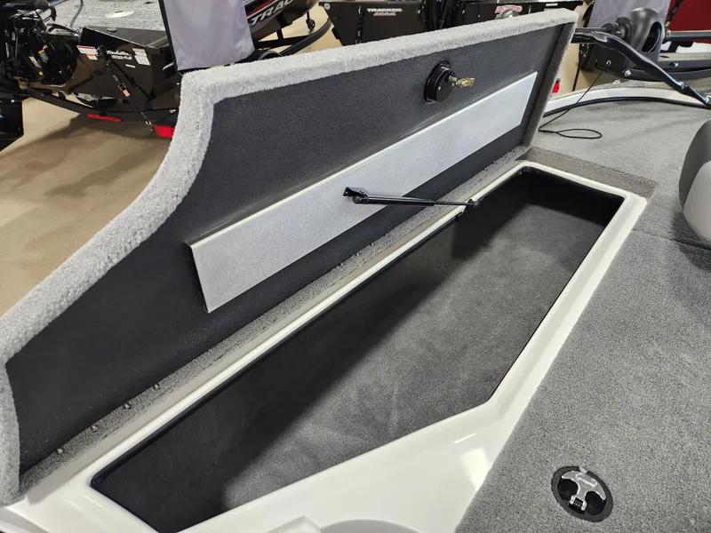 Slide: The Image of Open storage compartment in 2025 Nitro Z18 boat, featuring carpeted interior and hydraulic lift. - 12
