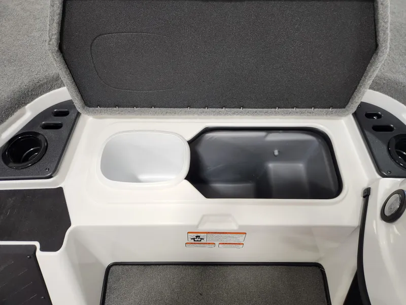 Slide: The Image of 2025 Nitro Z18 boat storage compartment with open lid and cup holders. - 14