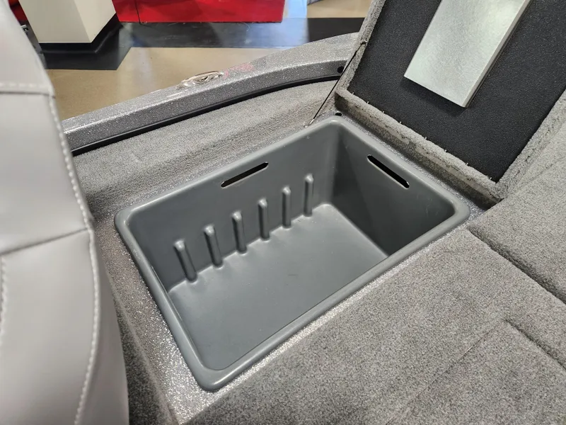 Slide: The Image of 2025 Nitro Z18 boat storage compartment with gray interior and carpeted surroundings. - 18