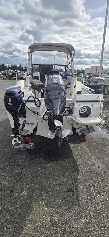 Slide: The Image of Bayliner 2002 WA 1997 model boat with dual outboard motors, parked on pavement. - 2