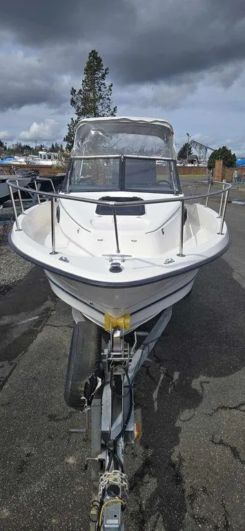 Slide: The Image of 1997 Bayliner 2002 WA boat on trailer, parked outdoors under cloudy sky. - 3