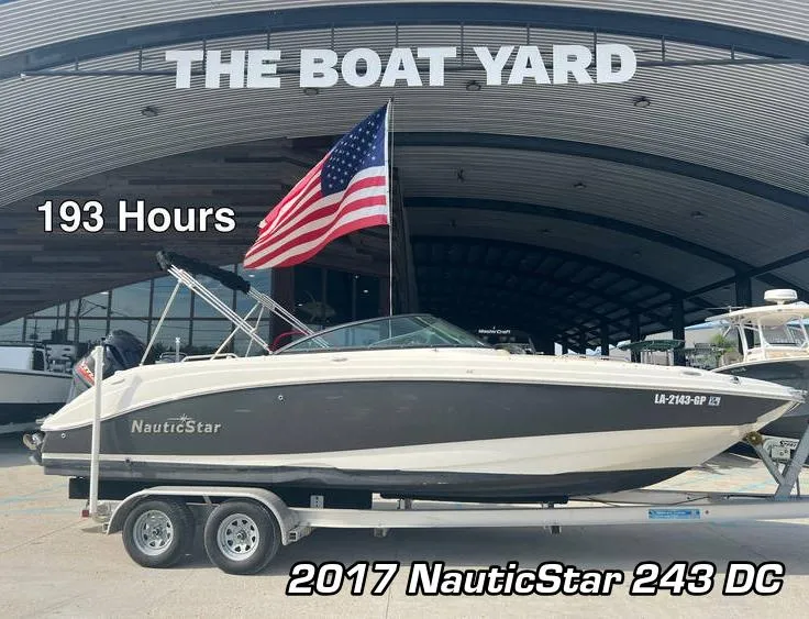 The Image of 2017 NauticStar 243 DC boat on trailer at The Boat Yard, 193 hours, American flag displayed. - 0