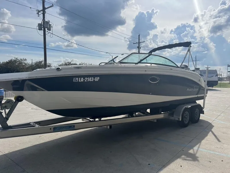 Slide: The Image of 2017 NauticStar 243 DC boat on trailer under cloudy sky. - 11