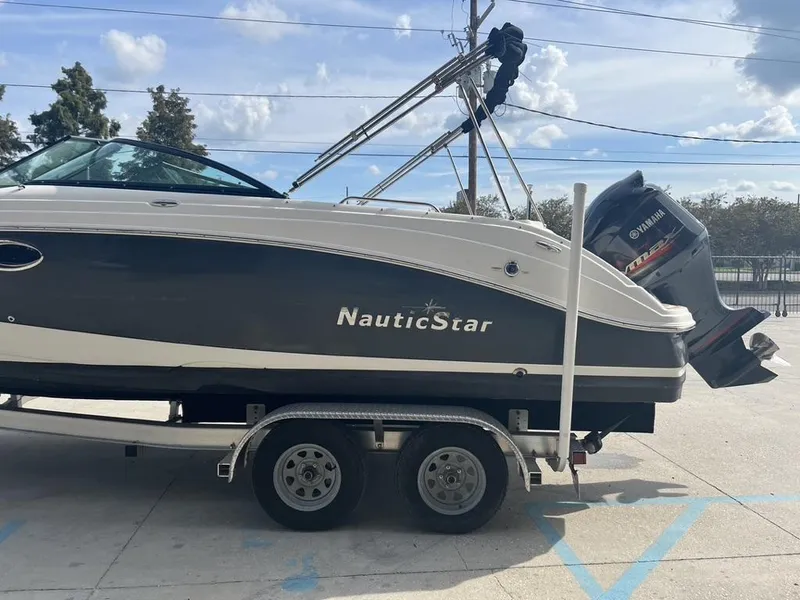 Slide: The Image of 2017 NauticStar 243 DC boat on trailer with Yamaha outboard motor, parked outdoors. - 13