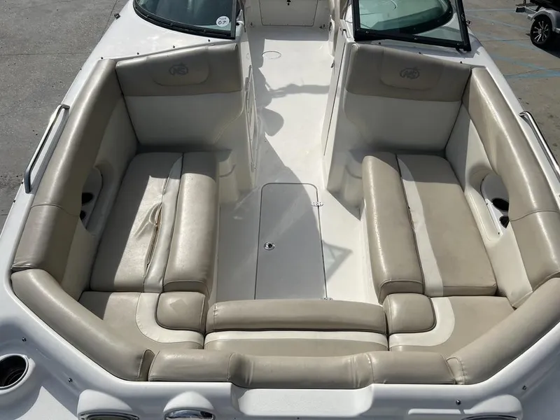 Slide: The Image of 2017 NauticStar 243 DC boat interior with beige seating and cup holders. - 3
