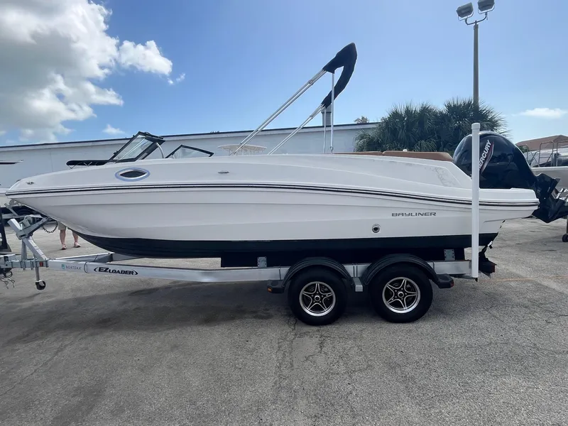 Slide: The Image of 2021 Bayliner VR6 Bowrider OB on trailer, parked outdoors under a cloudy sky. - 2