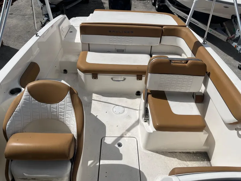 Slide: The Image of 2021 Bayliner VR6 Bowrider OB interior with tan and white seating, spacious layout. - 6