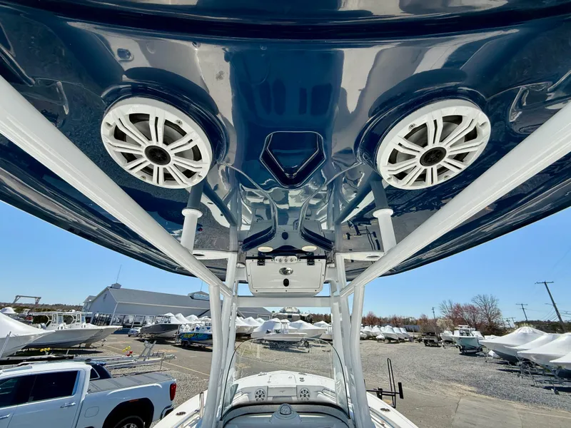 Slide: The Image of 2018 Tidewater 232 CC Adventure boat with speakers and T-top, parked outdoors. - 18