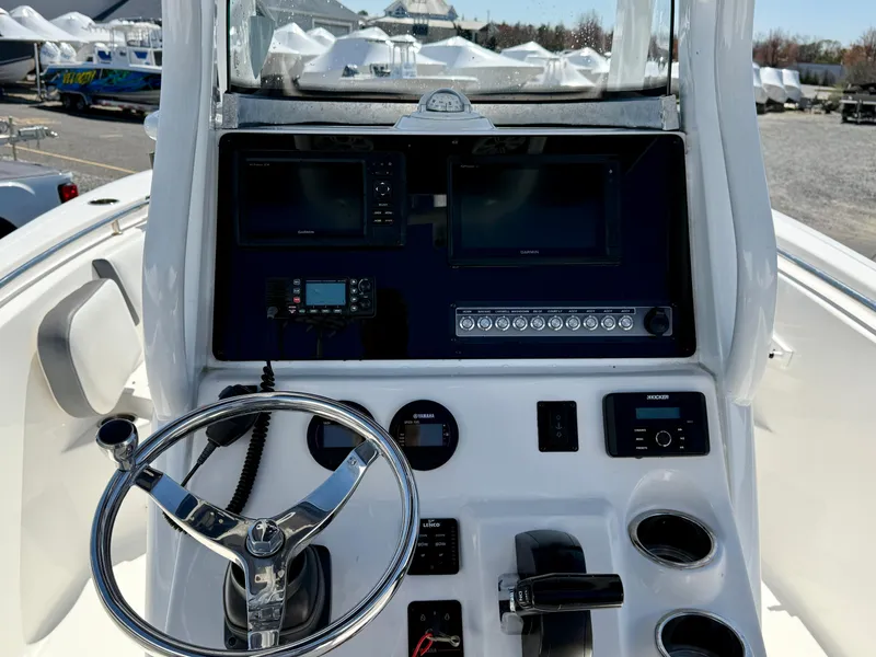 Slide: The Image of 2018 Tidewater 232 CC Adventure boat console with steering wheel and navigation controls. - 19
