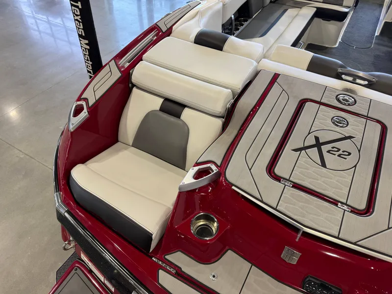 Slide: The Image of 2019 MasterCraft X22 boat interior with red and white seating and deck design. - 12