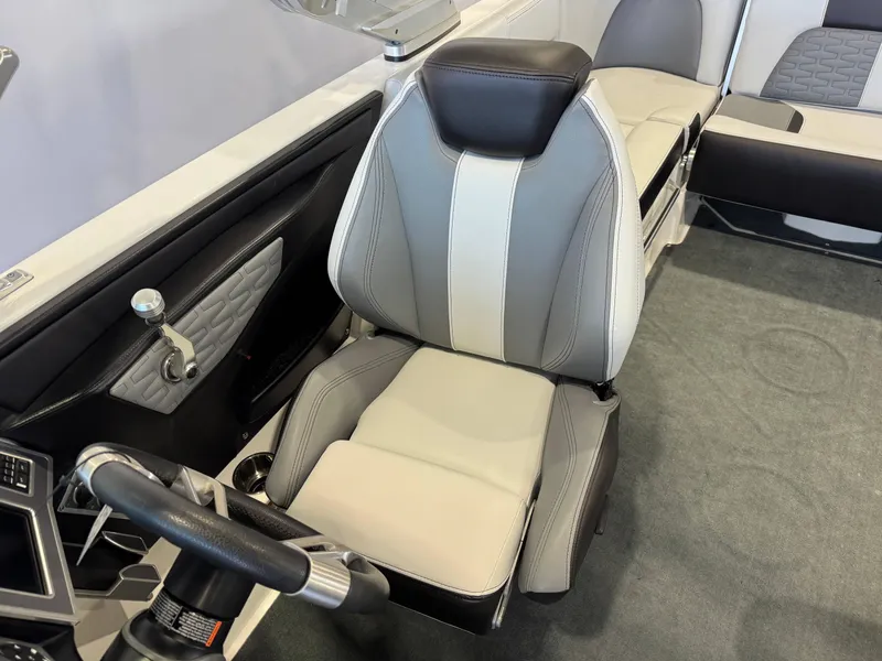 Slide: The Image of 2019 MasterCraft X22 boat interior with gray and white captain's seat and steering wheel. - 20