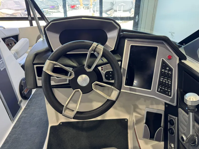 Slide: The Image of 2019 MasterCraft X22 boat dashboard with steering wheel and control panel. - 25