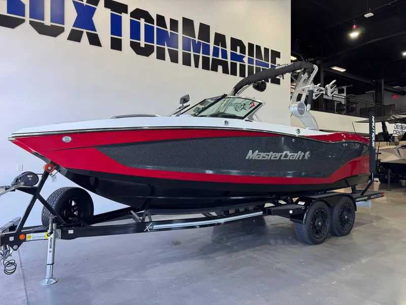 Slide: The Image of 2019 MasterCraft X22 boat in showroom, red and black design on trailer. - 3