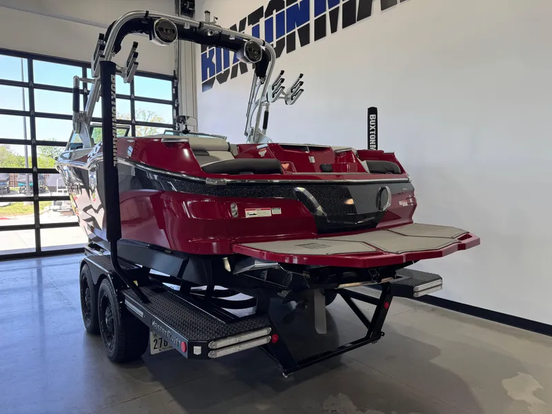 Slide: The Image of 2019 MasterCraft X22 boat in showroom, red and black, on trailer. - 5
