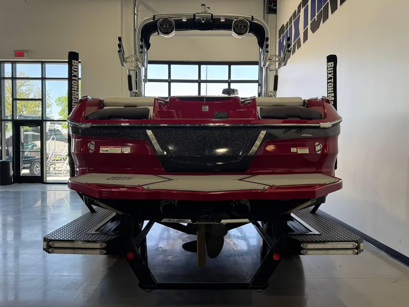 Slide: The Image of 2019 MasterCraft X22 boat in showroom, rear view, red and black design. - 6