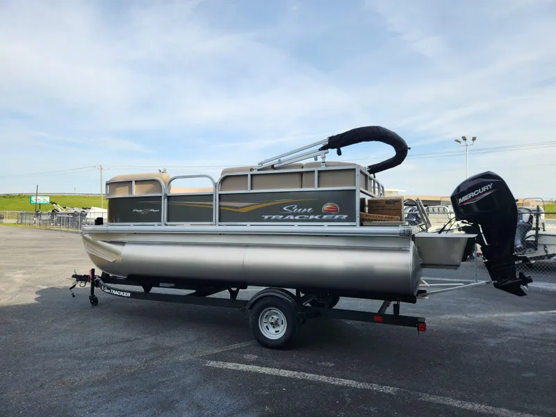 Slide: The Image of 2025 Sun Tracker Party Barge 16 DLX pontoon boat on trailer in parking lot. - 6