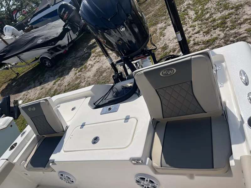 Slide: The Image of 2025 Key West 230 Bay Reef boat interior with seating and motor, parked outdoors. - 10