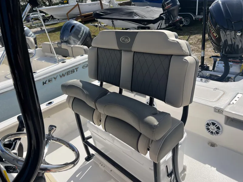 Slide: The Image of 2025 Key West 230 Bay Reef boat interior with cushioned seating and steering wheel. - 13