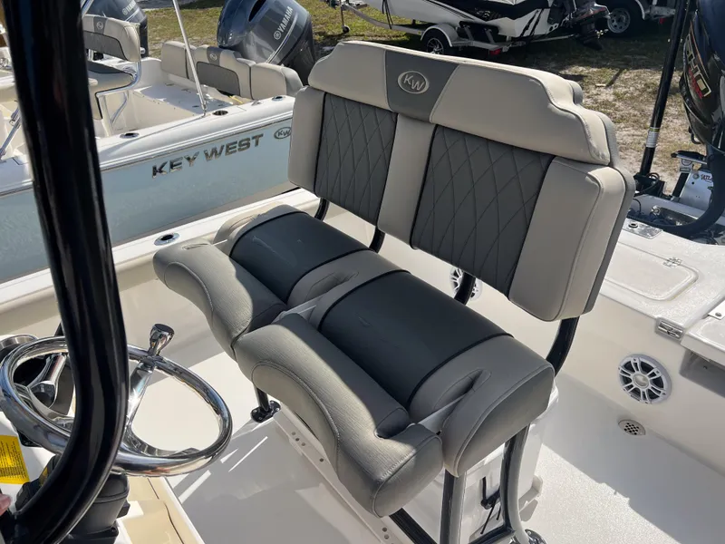 Slide: The Image of 2025 Key West 230 Bay Reef boat interior with cushioned seating and steering wheel. - 14